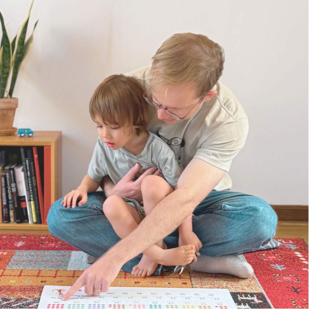 お風呂ポスターを男性と男の子が一緒に指を刺しながら見ている場面